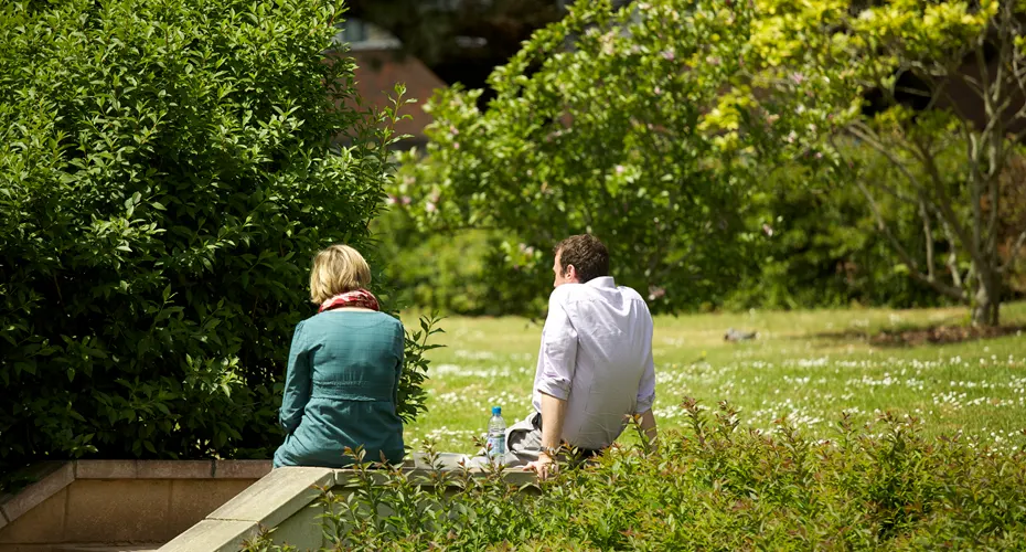 two people sitting together on the grass