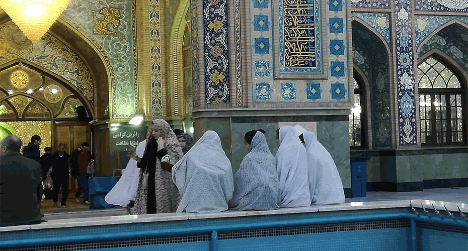 Ladies with heads covered in front of a mosaic