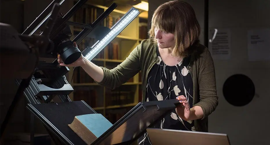 Image of a humanities student looking at an old book