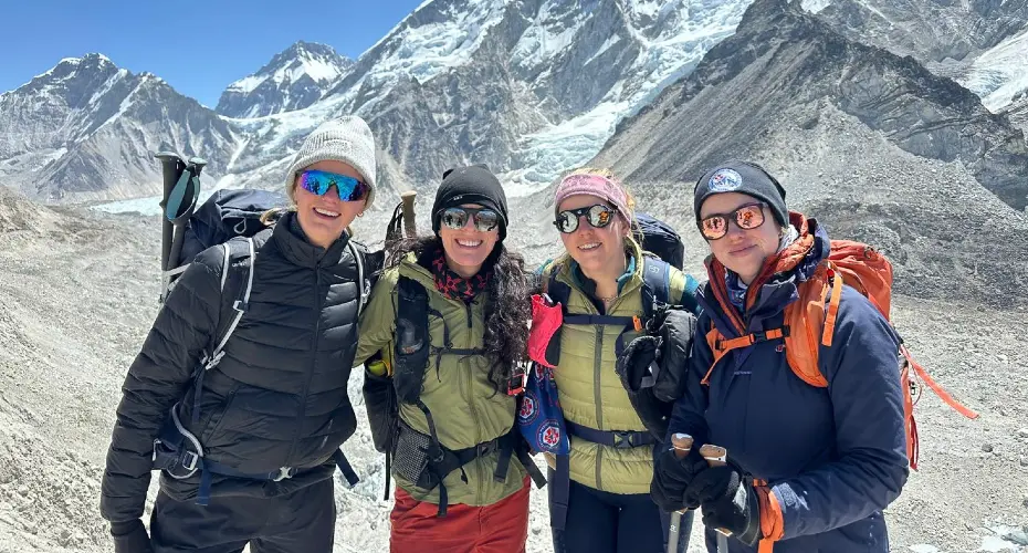 Four Extreme Medicine students wearing hats, sunglasses and jackets in a cold snowy mountain environment, smiling at the camera