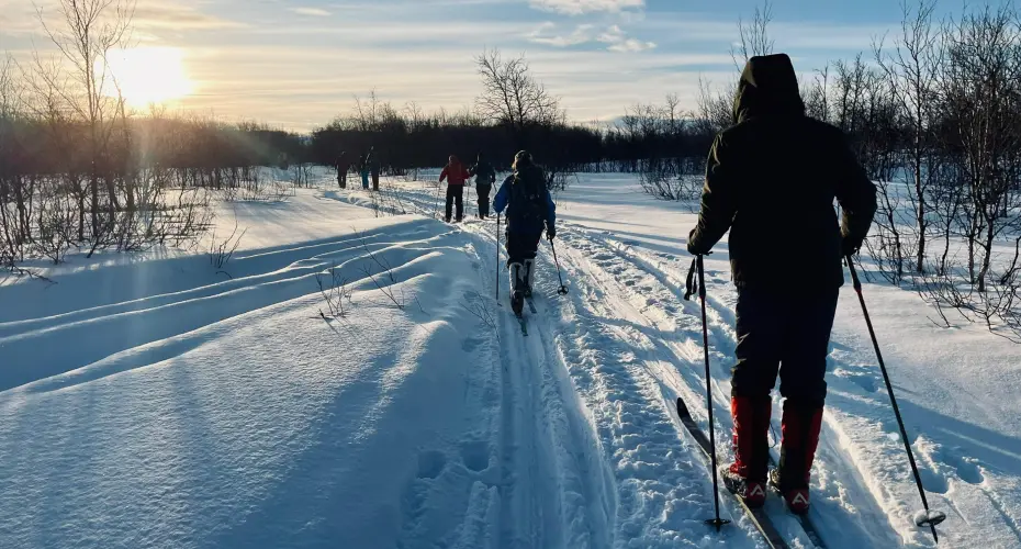 Extreme Medicine students walking on skis in the snow, facing away from the camera