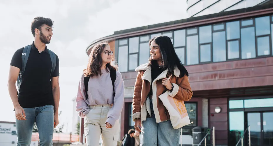 Three students chatting outside at Penryn Campus