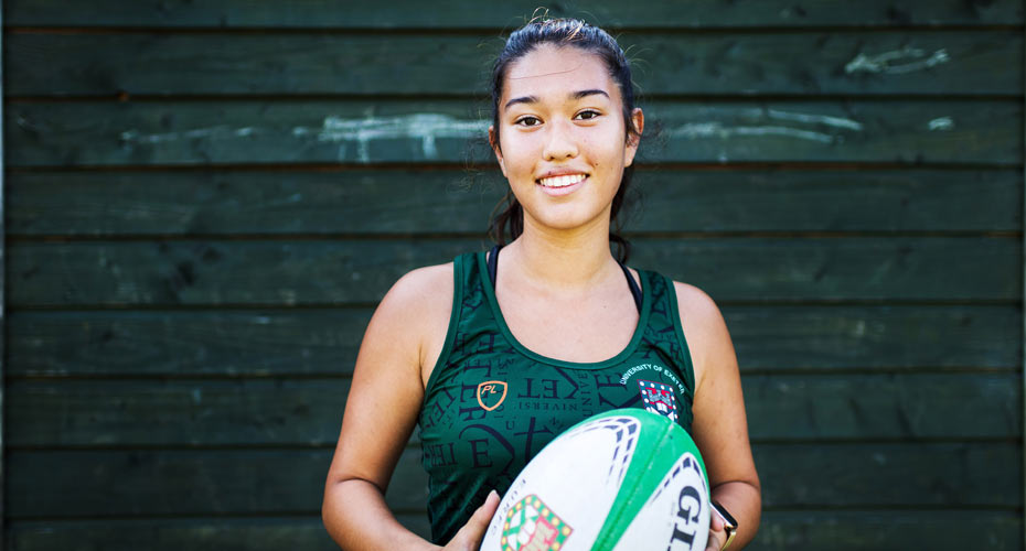a female rugby player holding a ball