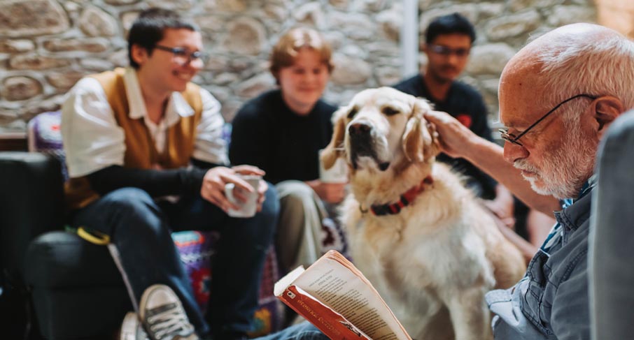 Students talking and reading with support dog