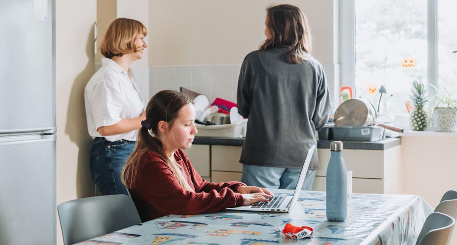 Penryn student working at table whilst other talk