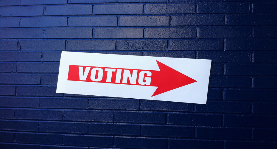 Voting sign on blue wall